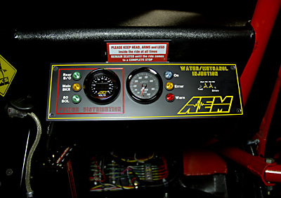 Right side of cab showing AEM water and methanol injection monitoring system and 12vdc monitoring. Custom 12vdc fuse and distribution buss at the bottom area of cockpit.